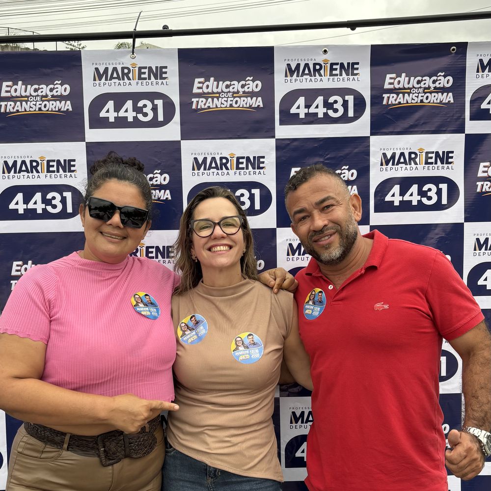 Professora Mariene com apoiadores em frente ao painel da campanha 4431